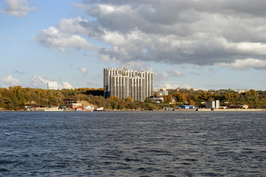 Construction of a multi-storey house on the river Bank. Autumn.