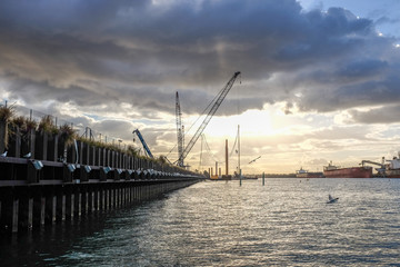 Fototapeta na wymiar Loading cranes and ship on harbour