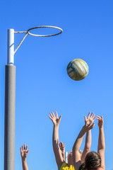 Netballers jumping for ball against blue sky © SCLifestyle