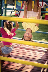 Obraz premium Our world is full of fun. Two little smiling girl in playground . Space for copy.