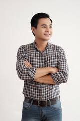 Portrait of young confident businessman in casual clothes standing with his arms folded