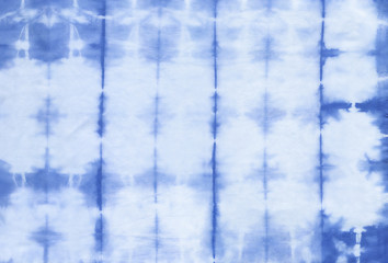 Abstract tie dyed fabric of indigo color on white cotton. Hand painted fabrics. Shibori dyeing