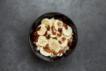 Healthy breakfast concept with oatmeal porridge with bananas,  nuts, raisins, sesame seeds  Top view. Super food. Food made of granola and musli.