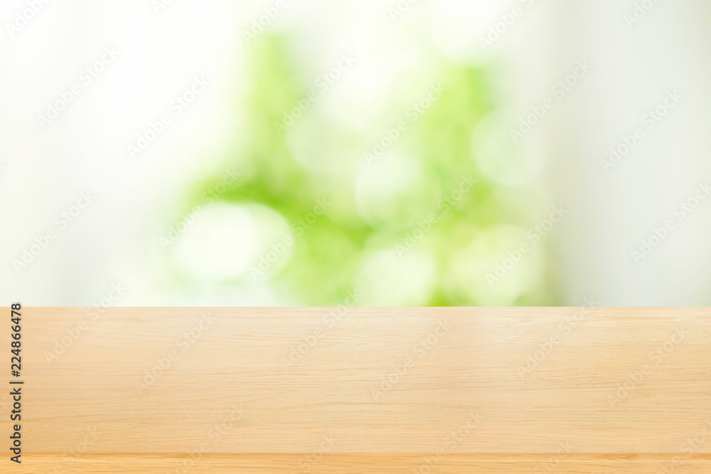 Poster empty of wooden table top on blur of abstract green from garden with sunlight and curtain window bac