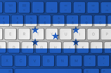 Honduras flag and computer keyboard in the background
