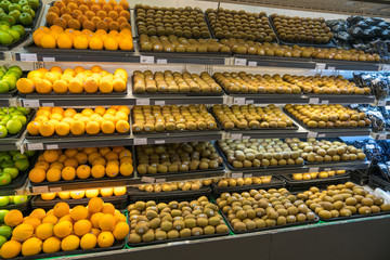 Fresh healthy fruits on shelves in supermarket