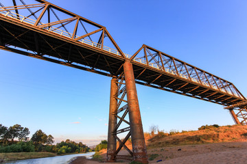 Low angle view of steel bridge over country river