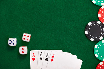 Aces, poker chips, dice on green velvet casino table. Gambling concept.