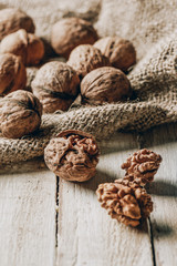 close-up view of whole and cracked walnuts and sackcloth on wooden table