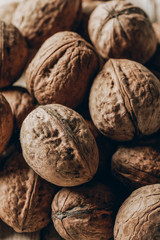 close-up view of heap of raw ripe walnuts on wooden table