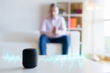 Man using virtual assistant, smart speaker at home