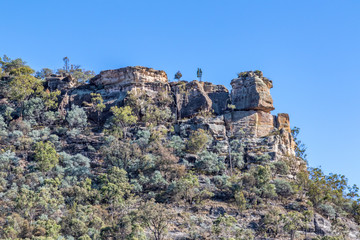 Fototapeta na wymiar View of tree lined rocky mountain and blue sky