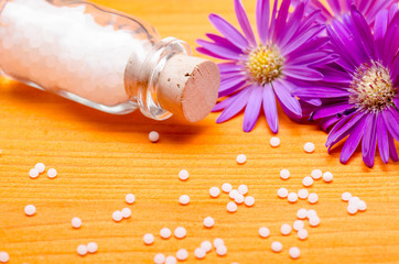homeopathic globules on a orange wooden background