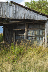 Old decayed shed on a field