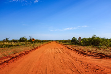 Fototapeta na wymiar Red dirt road leading to blue sky