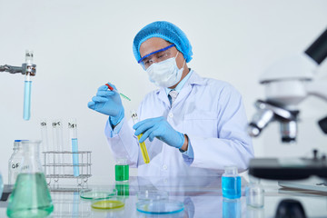 Scientist researcher man working with test liquid using micro pipette in science laboratory room
