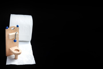 Wooden toy toilet on black background