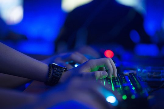 pc gamer holding hand on illuminated keyboard