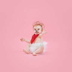 Fototapeta premium Newborn baby girl wearing a Halloween costume on pink studio background