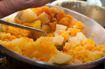 closeup of pumpkin and potatoes mashed in vegetable mill masher