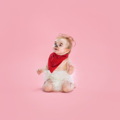 Fototapeta premium Newborn baby girl wearing a Halloween costume on pink studio background