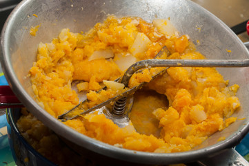 closeup of pumpkin and potatoes mashed in vegetable mill masher