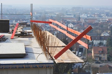 Aus der Betonwand herausstehende Baustahlenden auf dem oberen Stockwerk eines in den Steilhang...