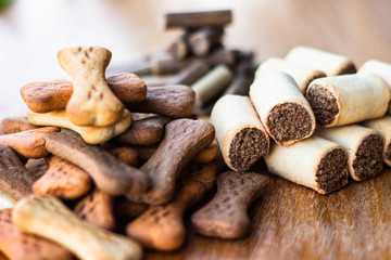 Dog tasty colored biscuits on wooden background, snacks for dogs