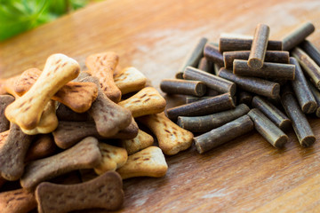 Dog tasty colored biscuits on wooden background, snacks for dogs