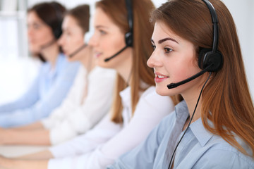 Call center. Beautiful cheerful smiling operator consulting clients with headset. Business concept...