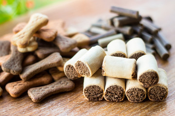 Dog tasty colored biscuits on wooden background, snacks for dogs