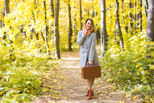 Autumn, nature and people concept - Young beautiful woman in grey coat in fall nature
