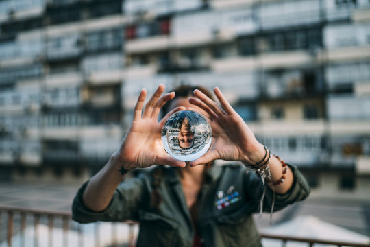 Redhead girl catching a crystal ball. Smile through the ball.