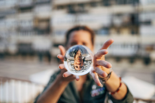 Redhead girl catching a crystal ball. Smile through the ball.