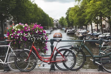 Fotobehang Fietsen langs een brug over de grachten van Amsterdam, Nederland © Hakan Kızıltan