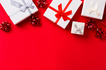 Red and white gift on red background with space for copy. Christmas concept.