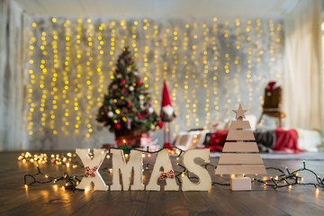 Wooden letters Xmas on the christmas tree background