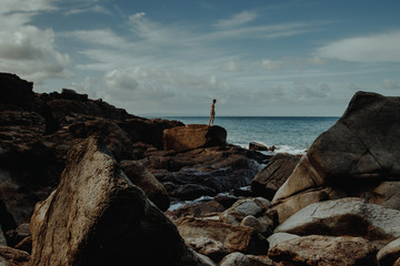 Traveler on rocks of shoreline