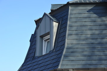 Frisch renoviertes, mit grauen Metallschindeln gedecktes Haus mit Aufkeilfenstern/Gaubenfenstern...