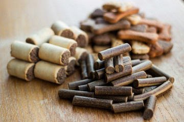 Dog tasty colored biscuits on wooden background, snacks for dogs 