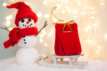 gift card with a new year and christmas with a picture of a snowman with a sleigh against a backdrop of glowing garlands