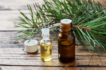 Cedar and spruce essential oil in small glass bottles on wooden background. Selective focus.