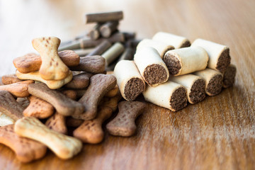 Dog tasty colored biscuits on wooden background, snacks for dogs 