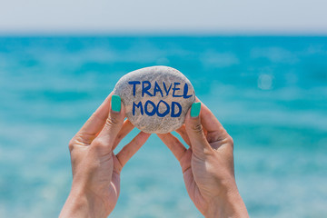 Girl holding round stone with sign about travel theme