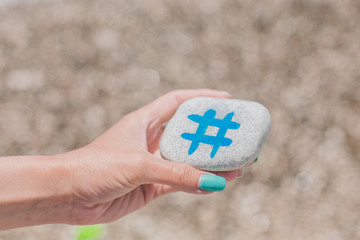 Girl holding round stone pebble with hashtag