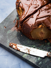 Dark Chocolate cake with pears and pistachio on green marble board