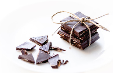 pack of dark chocolate cubes with a brown riben on a white background