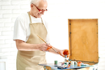 Close up of man choosing paints he needs to paint new painting.