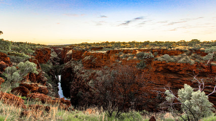 Scenic view over outback gorge with red rock and green trees