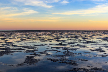 Obraz premium Sunrise over ocean mudflats at low tide